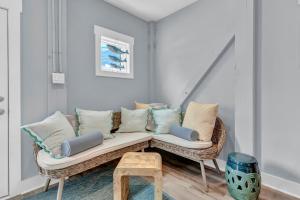 een rieten bank met kussens in de woonkamer bij Pinewalk by Sea Scape Properties in North Topsail Beach +40 foto's