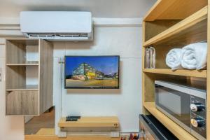 a room with a flat screen tv on a wall at โรงแรมชิบะรูม นครราชสีมา สาขามหาวิทยาลัยเทคโนโลยีสุรนารี in Nakhon Ratchasima