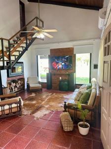 a living room with couches and a tv and a staircase at Chalet zona Norte con salida al lago "Casa Lila" in Federación