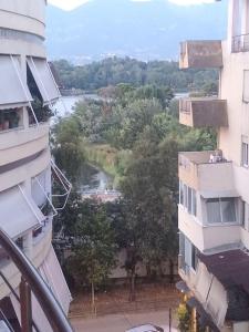 une vue sur une rivière depuis deux bâtiments dans l'établissement Tirana Lake Apartment, à Selitë e Vogël