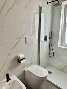 a white bathroom with a toilet and a sink at Golden Palm B&B in Bari