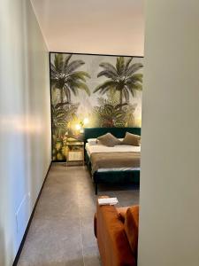 a bedroom with two beds and palm trees on the wall at Golden Palm B&B in Bari