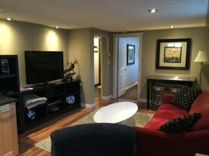 a living room with a red couch and a flat screen tv at The White Brick Inn in Jasper