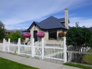 a white fence in front of a house with flowers at The White Brick Inn in Jasper
