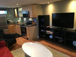 a living room with a large television and a kitchen at The White Brick Inn in Jasper