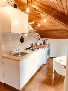 een keuken met witte kasten, een wastafel en een fornuis bij CASTAGNETO 8 in Rapallo