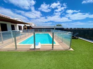 a swimming pool with a glass fence around it at Villa Abuelo Paco - Private heated pool in Playa Blanca