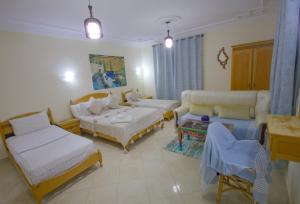 un soggiorno con due letti e un divano di Hotel Meftah Chaouen a Chefchaouen