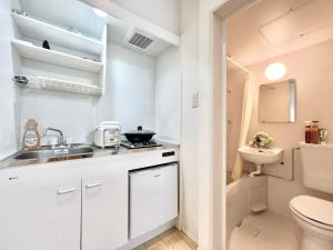 a small white kitchen with a sink and a toilet at Nerima house in Tokyo +41 photos