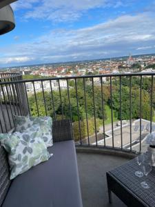a balcony with a couch and a view of a city at Skyline Suite Augsburg-Stilvoll & zentral in Augsburg