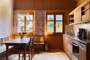 a kitchen with a table and chairs and two windows at NigschHof in Schoppernau
