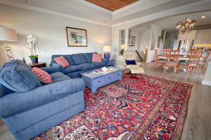 a living room with a blue couch and a rug at The Blue Pearl by Sea Scape Properties in Wrightsville Beach