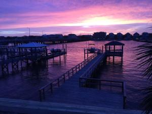 a dock with boats in the water at sunset at The Blue Pearl by Sea Scape Properties in Wrightsville Beach