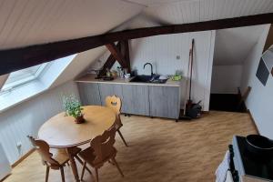 a kitchen with a table and chairs in a attic at Studio centre ville Schirmeck in Schirmeck