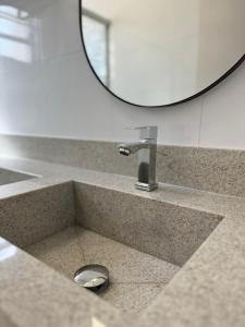 encimera con lavabo y espejo en Apartamento moderno próximo ao SESC, en Franca 16 fotos más