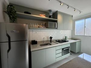 a kitchen with a refrigerator and a sink at Modern apartment near SESC in Franca