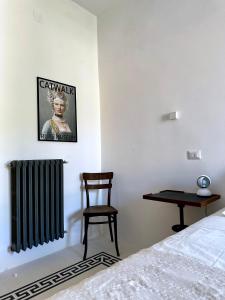 a bedroom with a bed and a chair and a radiator at Palazzo De Michele in Raiano