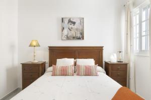 a bedroom with a large bed with two night stands at Villa Margarita in Conil de la Frontera