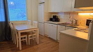 a kitchen with a table and a table and chairs at Uitontie Apartment in Kajaani