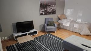 a living room with a flat screen tv and a couch at Uitontie Apartment in Kajaani