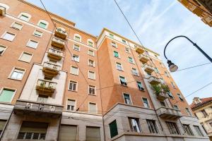 un grand bâtiment en briques rouges avec des balcons dans l'établissement San Tommaso, Luxury, 4 rooms, à Turin