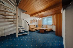 a living room with a staircase and a couch at Peak View Appartements in Vandans +80 photos