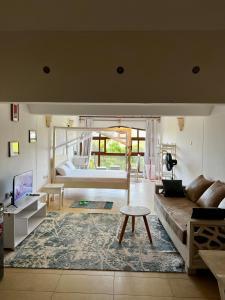 een woonkamer met een bank en een tafel bij Golden Sun Studio Apartment in Ukunda +22 foto's