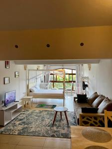 een woonkamer met een bed en een bank bij Golden Sun Studio Apartment in Ukunda