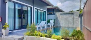 a house with a swimming pool and two white chairs at Luxury Private Pool Villa- Ao Nang Krabi in Ao Nam Mao