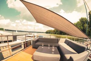 巴特萨罗皮斯库夫TraumZeitBoot Heidi - exklusiver Festlieger in perfekter Lage am Scharmützelsee Bad Saarow的一艘船,船上有一张沙发和一张桌子