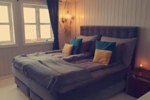 a large bed with pillows on it in a bedroom at Stor enebolig med flott hage og sommerstue in Skarpnes