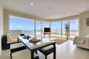 a living room with a table and a view of the ocean at Luxury Penthouse with Panoramic Sea Views in Canet de Berenguer