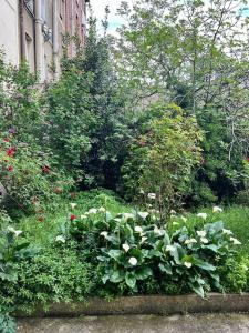 a garden with flowers and plants in front of a building at Charming Apartment - Near City Center, AC Included in Maisons-Alfort