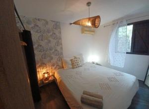 una camera da letto con un letto bianco e una finestra di Havre de paix ,vue sur l'ocean a La Possession