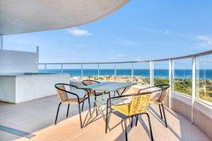 a balcony with a table and chairs and the ocean at Luxury Penthouse with Panoramic Sea Views in Canet de Berenguer