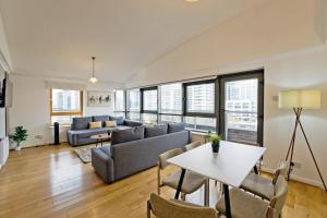 a living room with a couch and a table at Imperial Meridian Place Apartment in London