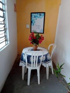 a white table with a vase of flowers on it at Casa azul in Barra Nova