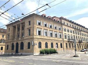 a large brick building on the corner of a street at Bright and Airy 1-Bedroom Flats in Neuchâtel City Center! RDM2 in Neuchâtel