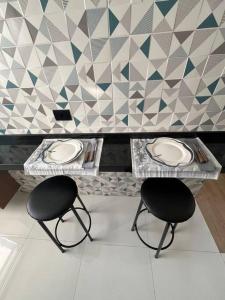 two black chairs and a table in a room at Apt próximo do metrô carrão in Sao Paulo