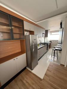 a large kitchen with a stainless steel refrigerator at Apt próximo do metrô carrão in Sao Paulo