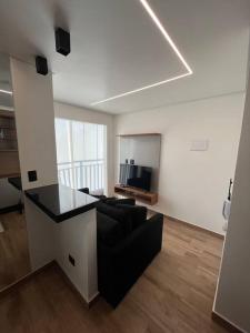 a living room with a black couch and a table at Apt próximo do metrô carrão in Sao Paulo
