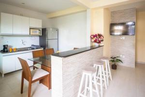 a kitchen with a counter and stools in a room at Recanto de Stella Maris in Salvador