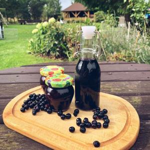 a bottle of syrup and blueberries on a wooden table at Willa Pod Lasem in Tupadły