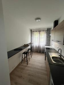 a kitchen with black counter tops and chairs in it at Appartement proche de la citadelle in Saint-André-lez-Lille