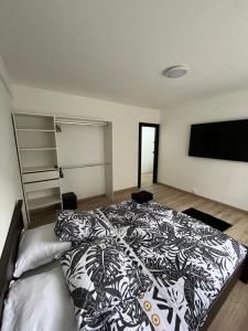 a bedroom with a bed with a black and white comforter at Appartement proche de la citadelle in Saint-André-lez-Lille