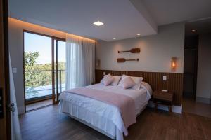 a bedroom with a large bed and a large window at Casa Oceano- Praia do Forte in Praia do Forte +39 photos