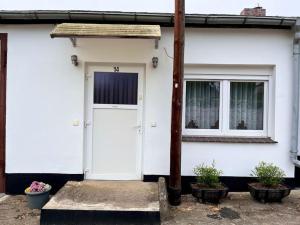 Casa blanca con puerta blanca y 2 ventanas en Turmhof Jüterbog, en Jüterbog