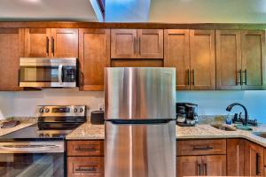 a stainless steel refrigerator in a kitchen with wooden cabinets at Retreat on the Lake in Hiawassee +53 photos