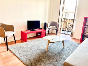 - un salon avec une télévision et une table rouge dans l'établissement Appartement idéal en plein centre ville proche lac, à Annecy