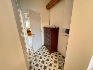 a hallway with a dresser and black and white tiles at City buzz by Mili in Belgrade